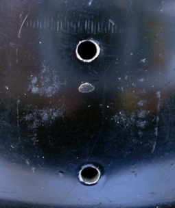 Trous de fixation et traces de l'insigne.