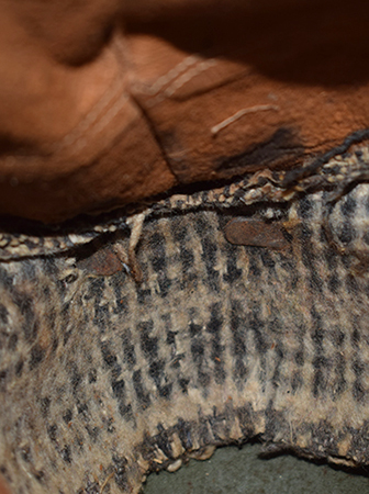 Agrafe double retenant le bandeau en drap de la coiffe.