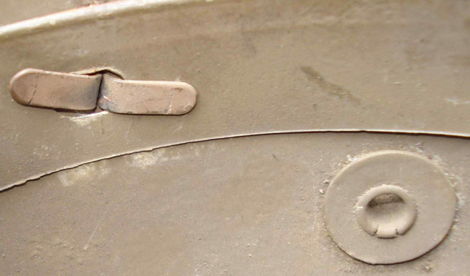 Cerclage de coiffe métallique fixé par 3 rivets fendus.