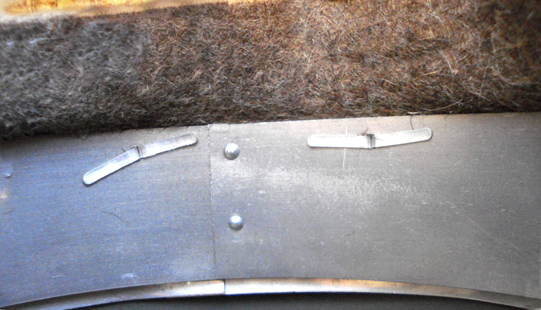 Fermeture du cerclage intérieur et pattes des rivets maintenant le cuir. Fermeture du cerclage intérieur et pattes des rivets maintenant le cuir.