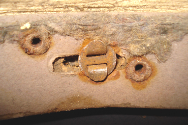 Fixation latérale à la coque entourée des rivets retenant le liège. Fixation latérale à la coque entourée des rivets retenant le liège.