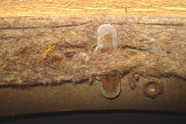 Fixation latérale à la coque entourée des rivets retenant le liège. Fixation latérale à la coque entourée des rivets retenant le liège.