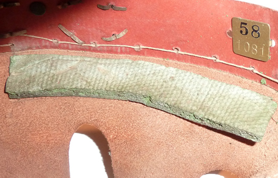 Tampon amortisseur latéral, couture de la coiffe en cuir au cerclage en carton compressé. Tampon amortisseur latéral, couture de la coiffe en cuir au cerclage en carton compressé.