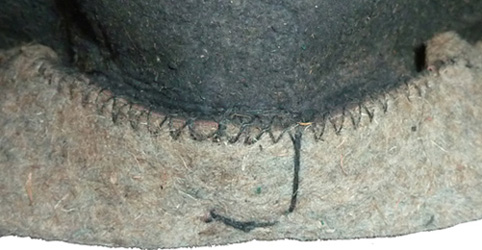 Couture de la pliure pratiquée sur les côtés de la coiffe.