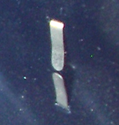 Agrafe crampon repliée dans la bombe. Agrafe crampon repliée dans la bombe.