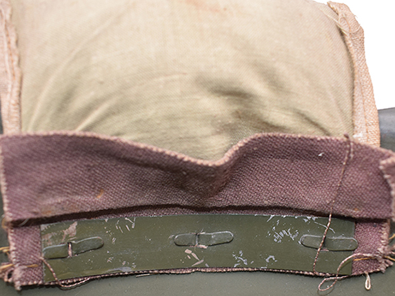 Patte de coiffe plaqu&eacute;e par une bande m&eacute;tallique.