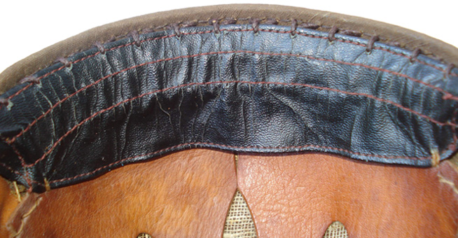 Bandeau frontal fixé en deux points à la coiffe et cousu sur la bordure de la bombe.