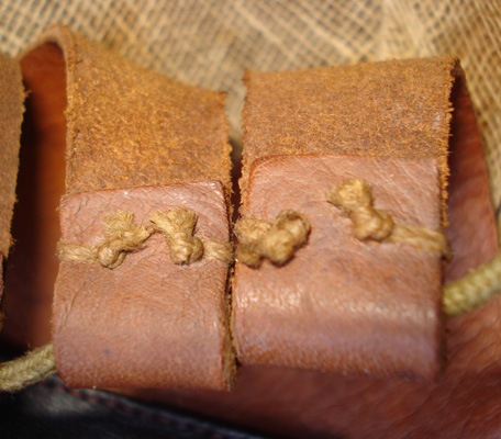 Extrémités pattes de cuir et passage du lacet.