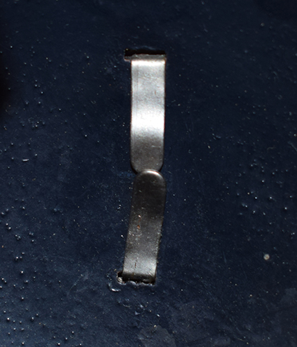 Patte de maintien de l'insigne.