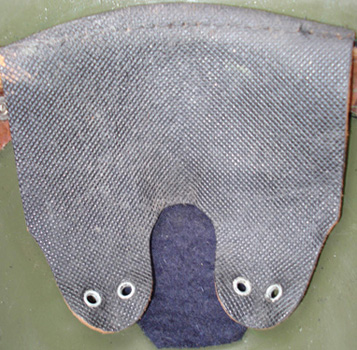 Patte de coiffe, cuir strié, trous renforcés par un œillet métallique creux.