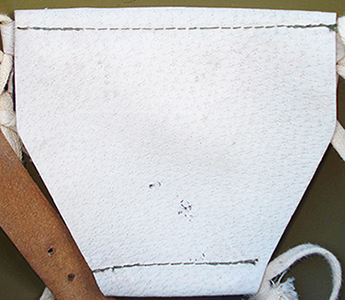 Patte de coiffe en cuir blanc.