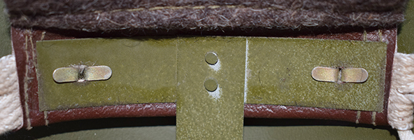 Patte de coiffe maintenue par deux attaches parisiennes.