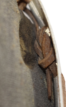 N&oelig;ud lacet en cuir retenant la coiffe.