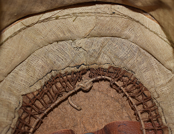 Doublure en toile rembourée terminée par un filet et son cordon de réglage. Doublure en toile rembourée terminée par un filet et son cordon de réglage.