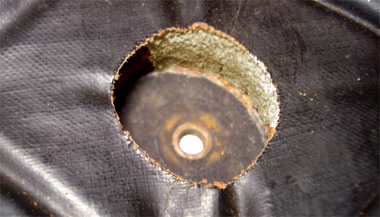 Vue intérieure du rivet-œillet, au fond de l'alvéole ménagée dans le tampon. Vue intérieure du rivet-œillet, au fond de l'alvéole ménagée dans le tampon.