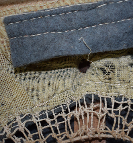 Doublure et bandeau en feutre, notez le rivet de maintien. Doublure et bandeau en feutre, notez le rivet de maintien.