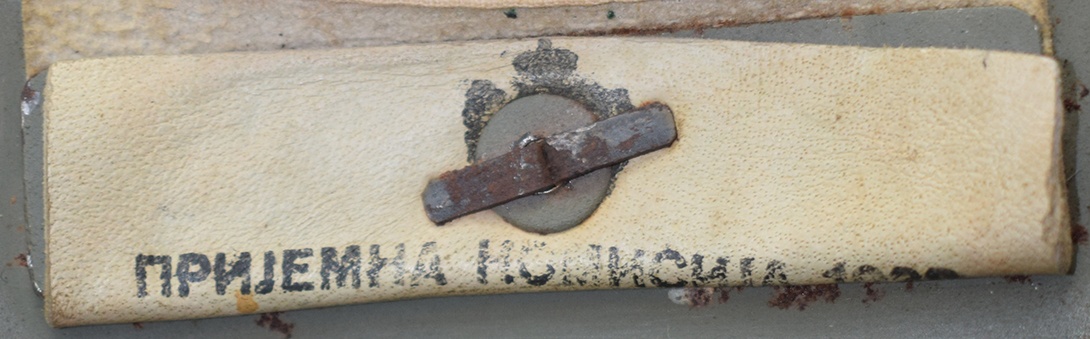 Patte de coiffe maintenue par une plaque métallique, maintien renforcé d'une rondelle. Patte de coiffe maintenue par une plaque métallique, maintien renforcé d'une rondelle.